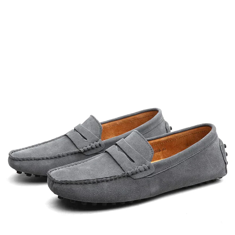 Mocassins en daim gris pour homme, au design simple et moderne. Confort exceptionnel grâce à la semelle à picots et à la douceur du cuir, idéals pour un usage quotidien et un look décontracté.