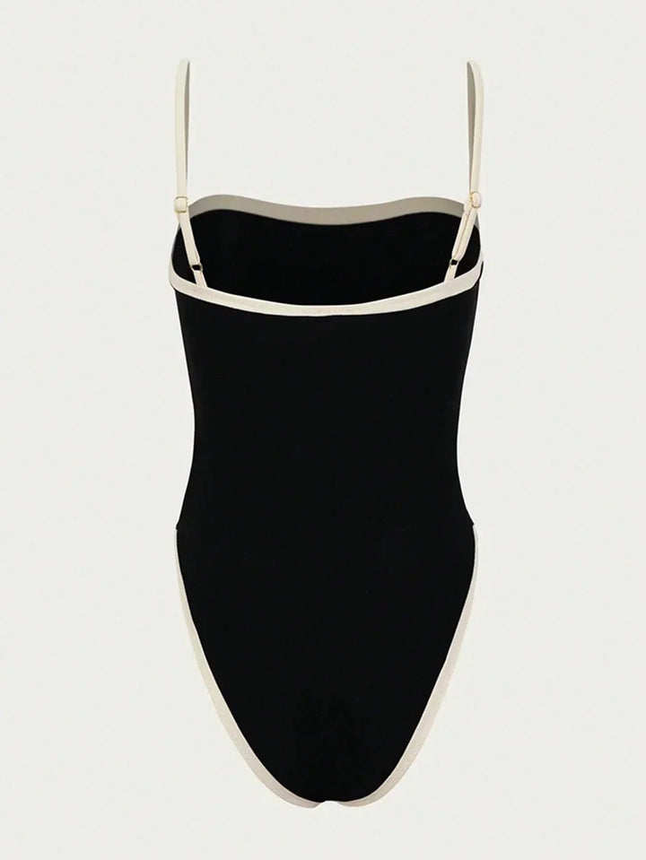 Maillot de bain femme une pièce noir avec bordures blanches contrastées, vue arrière avec fines bretelles réglables, offrant une coupe élégante, moderne et confortable.