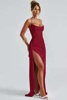 Robe de soirée Landry en satin bordeaux, avec un décolleté flatteur et une fente haute sur le côté qui met en valeur la silhouette. Son design élégant et sophistiqué avec des bretelles fines en fait la robe idéale pour une soirée chic et mémorable.