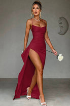 Robe de soirée Landry en satin bordeaux, mettant en valeur une silhouette élégante avec un décolleté flatteur et une fente haute. Les bretelles fines et la coupe fluide de cette robe créent un look audacieux et raffiné, idéal pour une soirée glamour.