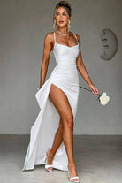Robe de soirée en satin blanc, avec décolleté élégant et fente haute sur le côté, offrant une allure sophistiquée et raffinée. Idéale pour une soirée chic, elle allie sensualité et confort.