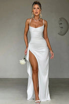 Robe de soirée en satin blanc avec fente haute, offrant un décolleté délicat et une coupe flatteuse, idéale pour des événements élégants. Parfaite pour une occasion spéciale, elle combine raffinement et sensualité.