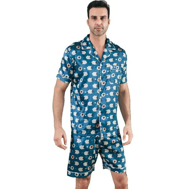 Homme portant le pyjama satin Laurent pour homme, ensemble deux pièces avec chemise boutonnée à manches courtes et short assorti, imprimé décoratif bleu à motifs, coupe droite, présenté sur fond blanc.