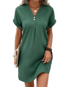 Femme portant une robe courte verte à rayures, élégante et légère, parfaite pour l'été. Un design simple et chic avec des boutons à l'encolure, idéale pour une tenue décontractée et stylée.