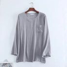 Haut de pyjama pour homme en tissu gris clair, à manches longues, avec encolure ronde, petite patte de boutonnage et poche poitrine. Matière douce et confortable, idéale pour la détente et les nuits paisibles.