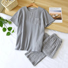 Pyjama pour homme composé d’un haut gris clair à manches courtes avec poche poitrine et d’un pantalon assorti à motif carreaux. Ensemble doux, léger et très confortable, idéal pour la détente et les nuits paisibles.