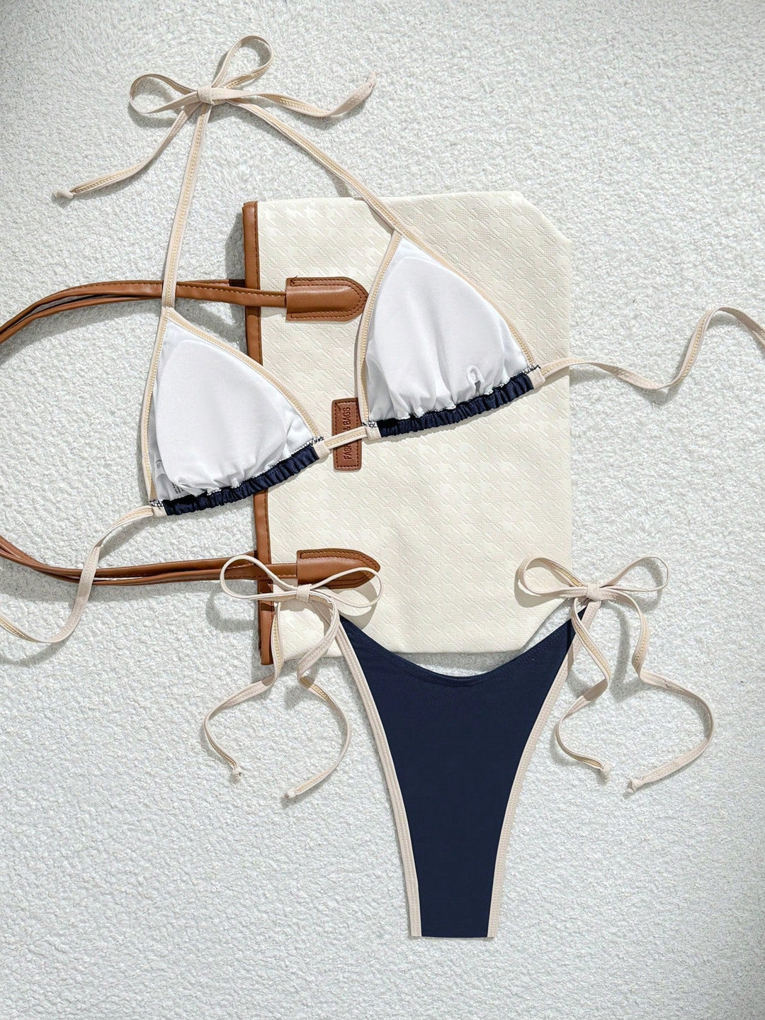 Bikini triangle femme Letty blanc et bleu marine avec liens à nouer, design élégant et coupe sexy, présenté avec un sac pour un style tendance et confortable.