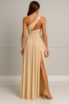 Vue arrière de la robe de soirée en satin beige pour femme, montrant le design asymétrique avec une seule bretelle et un dos ouvert qui met en valeur la silhouette. La fente latérale ajoute une touche de sensualité et de sophistication, idéale pour un événement spécial ou une soirée élégante.