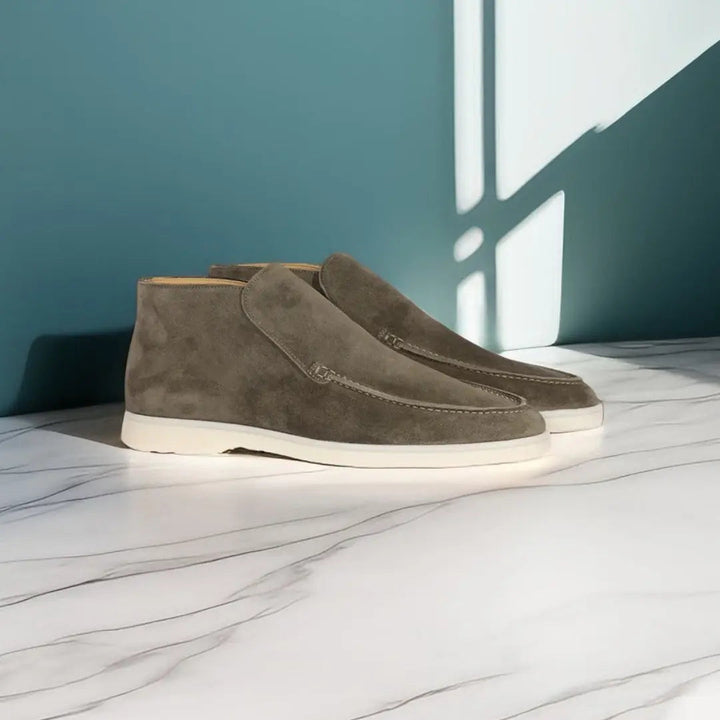 Mocassins en daim gris pour homme, avec semelle blanche, alliant confort et élégance pour un usage quotidien. Leur design intemporel et leur texture en daim de qualité en font une paire idéale pour compléter vos tenues avec style.