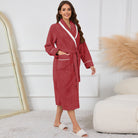 Peignoir femme confortable Lison en tissu gaufré rouge bordeaux avec col châle blanc, ceinture et poches, porté debout en intérieur.
