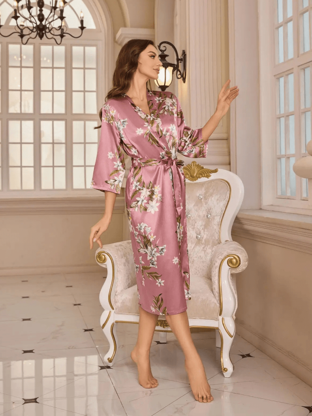 un peignoir long en satin rose à motifs floraux, doté d’une ceinture, offrant une allure raffinée et luxueuse.