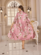un peignoir long en satin rose à motifs floraux, au tombé fluide et raffiné, mettant en valeur son élégance et la qualité du tissu.
