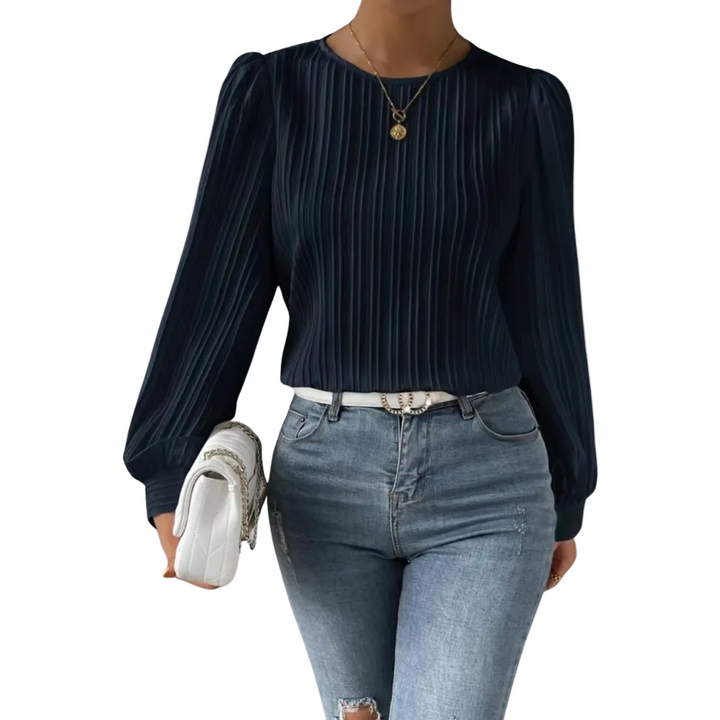 Top Lorna pour femme, élégant et confortable, coupe ajustée avec manches longues légèrement bouffantes, tissu plissé coloris bleu foncé, porté avec un jean pour un look chic et moderne.
