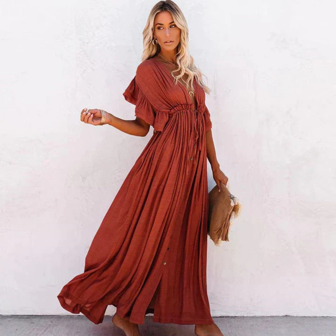 Avec ses manches volantées, sa taille cintrée et ses boutons sur toute la longueur, cette robe longue offre un look élégant et décontracté, parfait pour les journées ensoleillées.