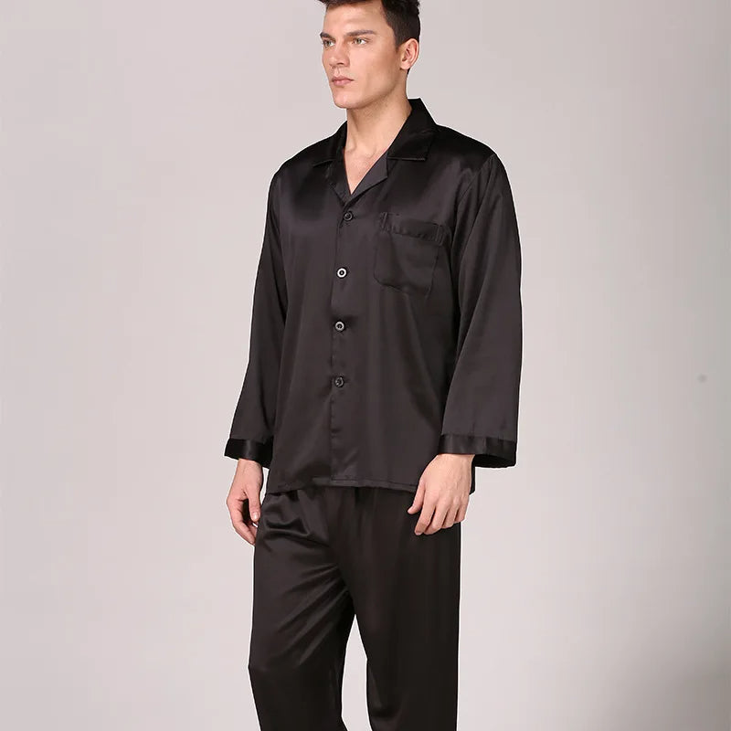 Homme portant un pyjama satiné bleu marine composé d’une chemise à manches longues avec poche poitrine et d’un pantalon assorti. Ensemble doux, élégant et très confortable, idéal pour des nuits sophistiquées et agréables.
