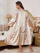 en satin champagne, long et fluide. Le tissu soyeux et la coupe ample mettent en valeur la douceur, la légèreté et l’élégance raffinée du modèle.