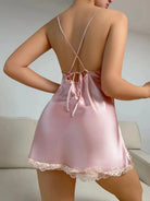 Vue arrière d'une nuisette en satin rose délicat, avec des bretelles croisées et un joli lien au dos pour un ajustement personnalisé. La dentelle fine qui orne le bas de la nuisette ajoute une touche de sensualité. Un modèle à la fois élégant et raffiné, parfait pour des moments de confort et de luxe.