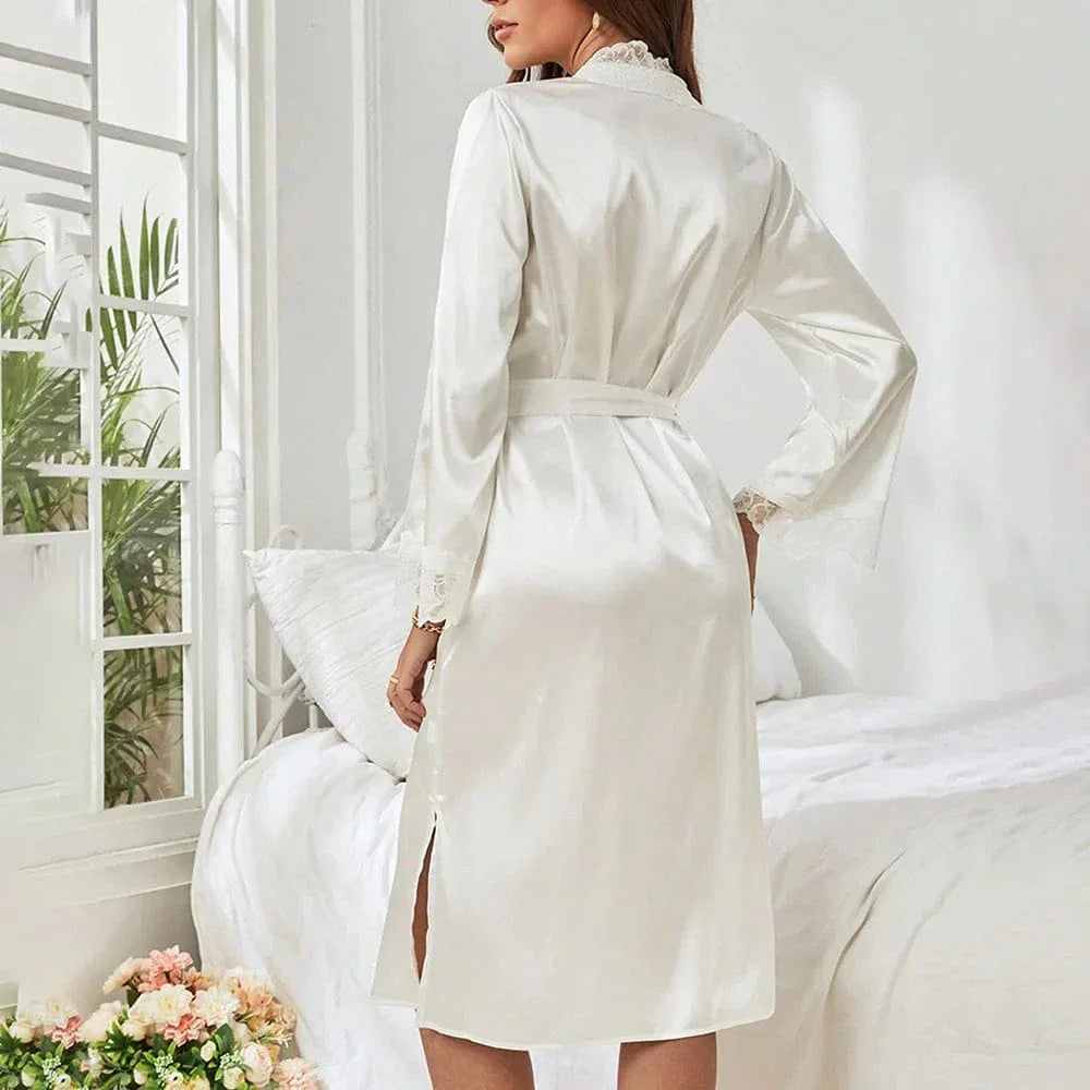 Femme souriante portant le peignoir en satin Mélodie de couleur champagne, ceinturé à la taille, avec dentelle élégante sur les manches et l&