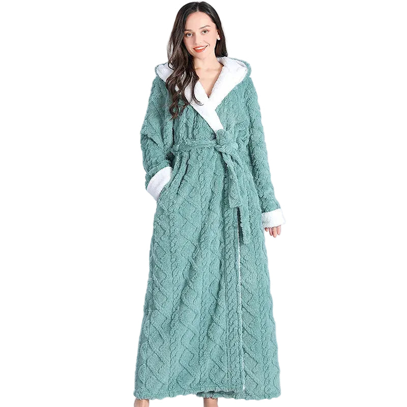 Femme portant le peignoir Maïa, modèle chaud et confortable en tissu texturé vert avec doublure blanche douce, présenté debout sur fond blanc.