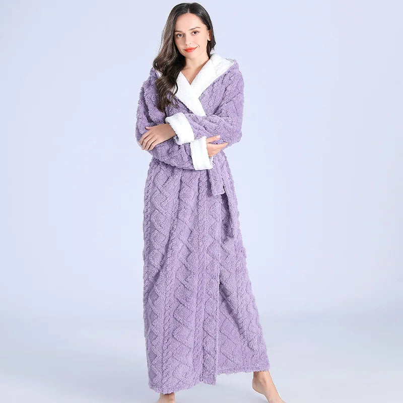 Femme portant le peignoir Maïa chaud et confortable, modèle violet à texture douce avec doublure blanche et ceinture assortie, posant debout avec les bras croisés.