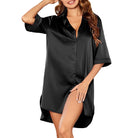 Femme portant une nuisette en satin noir, coupe chemise ample avec manches courtes et fermeture boutonnée. Tissu fluide, doux et brillant pour un confort optimal et une élégance raffinée, idéale pour les nuits ou les moments de détente à la maison.