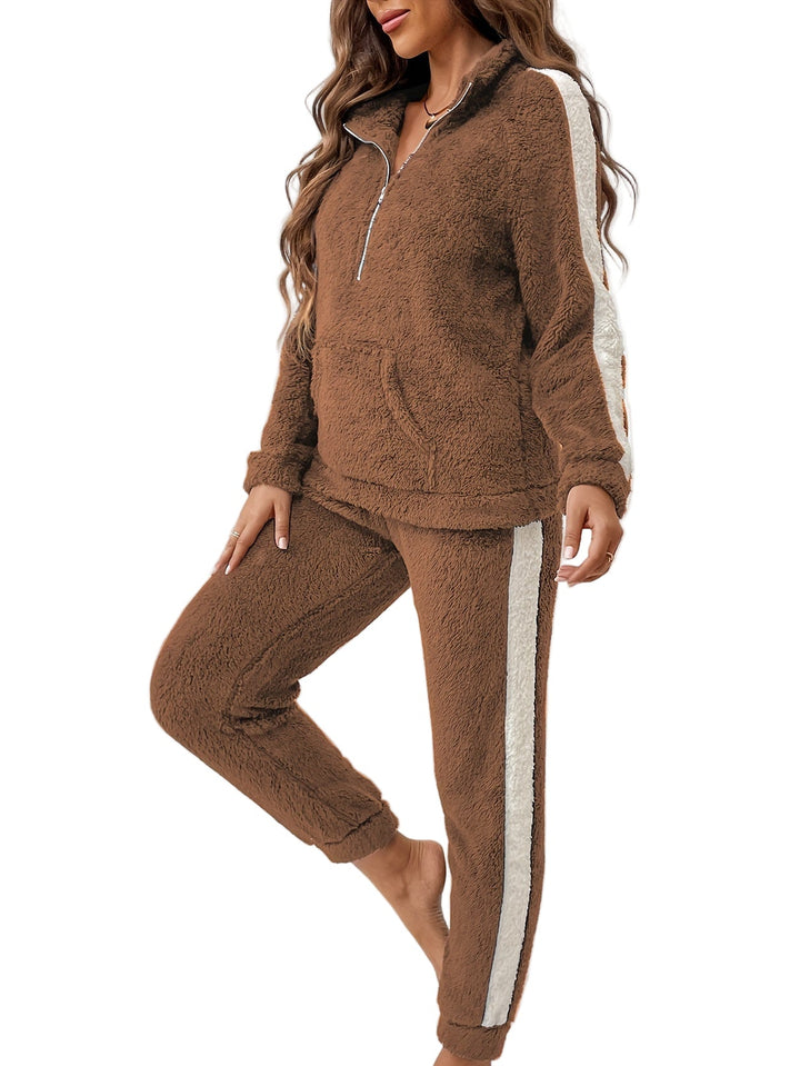 Femme portant un pyjama deux pièces marron ultra moelleux avec fermeture éclair et bandes contrastées blanches sur les manches et les jambes, idéal pour des moments cocooning à la maison en toute chaleur et douceur.