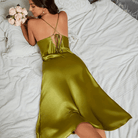 Vue arrière de la robe en satin vert olive, avec des bretelles croisées et un lien au dos pour un ajustement personnalisé. La coupe fluide et lisse de la robe accentue la silhouette, tandis que la brillance du satin et le détail élégant du dos ajoutent une touche séduisante, idéale pour des moments de luxe et de raffinement.