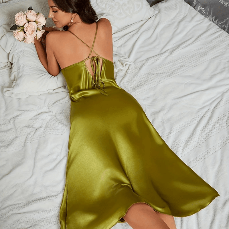 Vue arrière de la robe en satin vert olive, avec des bretelles croisées et un lien au dos pour un ajustement personnalisé. La coupe fluide et lisse de la robe accentue la silhouette, tandis que la brillance du satin et le détail élégant du dos ajoutent une touche séduisante, idéale pour des moments de luxe et de raffinement.
