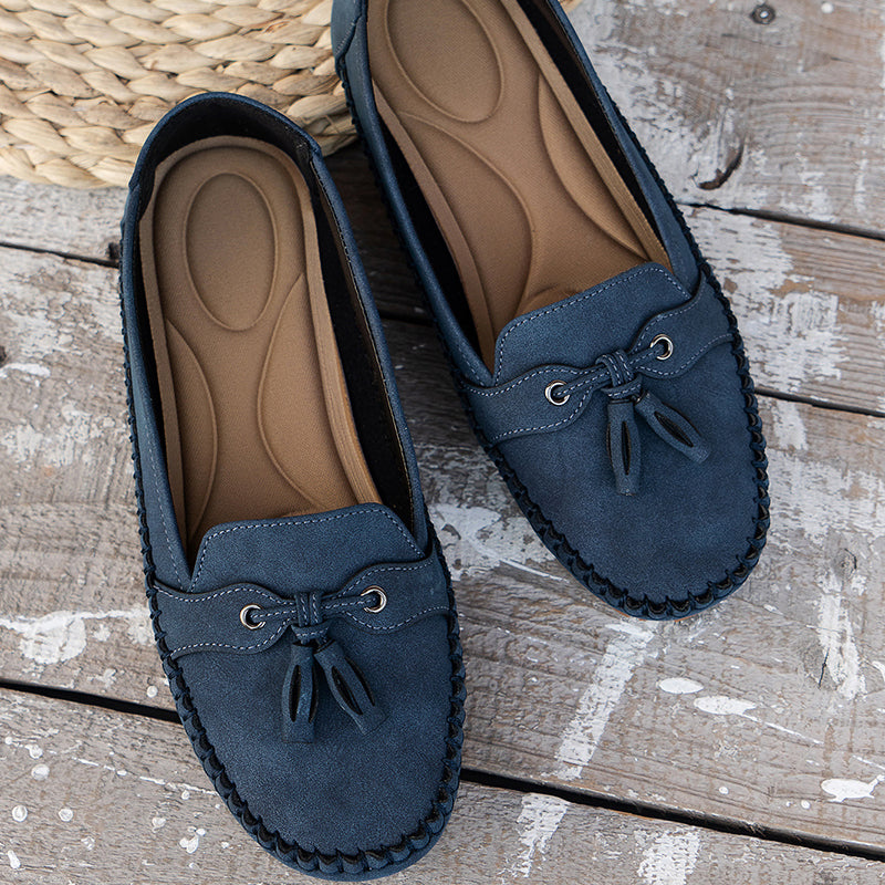 Vue de dessus des mocassins bleu foncé, mettant en valeur leur design soigné avec un petit nœud décoratif et des œillets en métal. L&