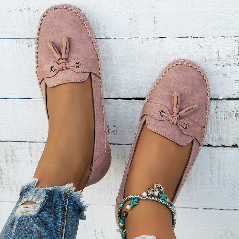 Vue de dessus des mocassins roses, mettant en avant leur design élégant avec un petit nœud décoratif et des œillets en métal. Les coutures soignées et la semelle confortable offrent un parfait équilibre entre style et bien-être. Ces mocassins sont parfaits pour une allure décontractée et raffinée, idéals pour le quotidien.