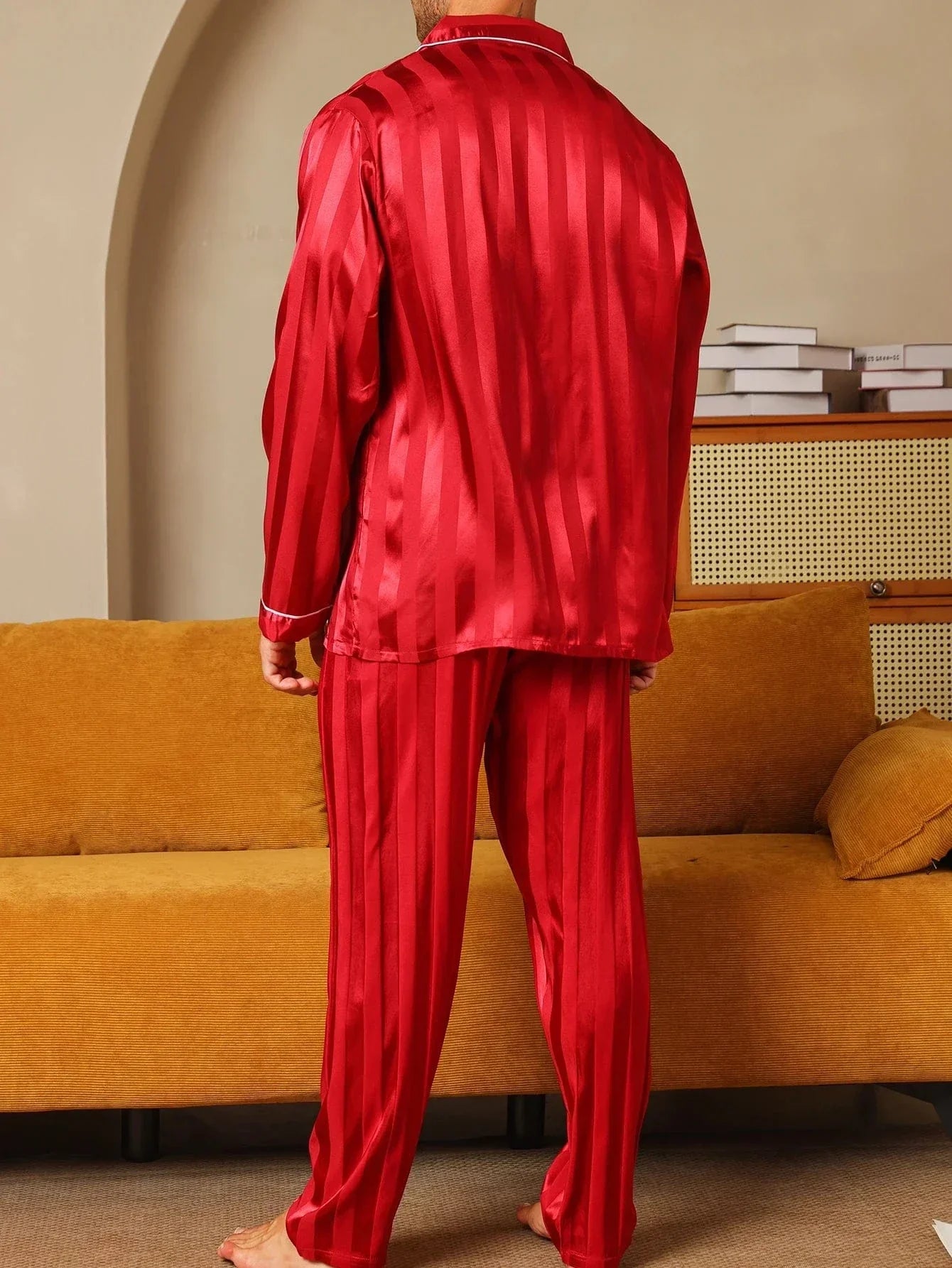 Vue de dos d’un homme portant le pyjama satin pour homme Maurice, ensemble élégant et confortable en satin rouge à fines rayures, composé d’une chemise à manches longues et d’un pantalon assorti, offrant une coupe soignée et un tombé fluide idéal pour la nuit ou la détente à la maison.