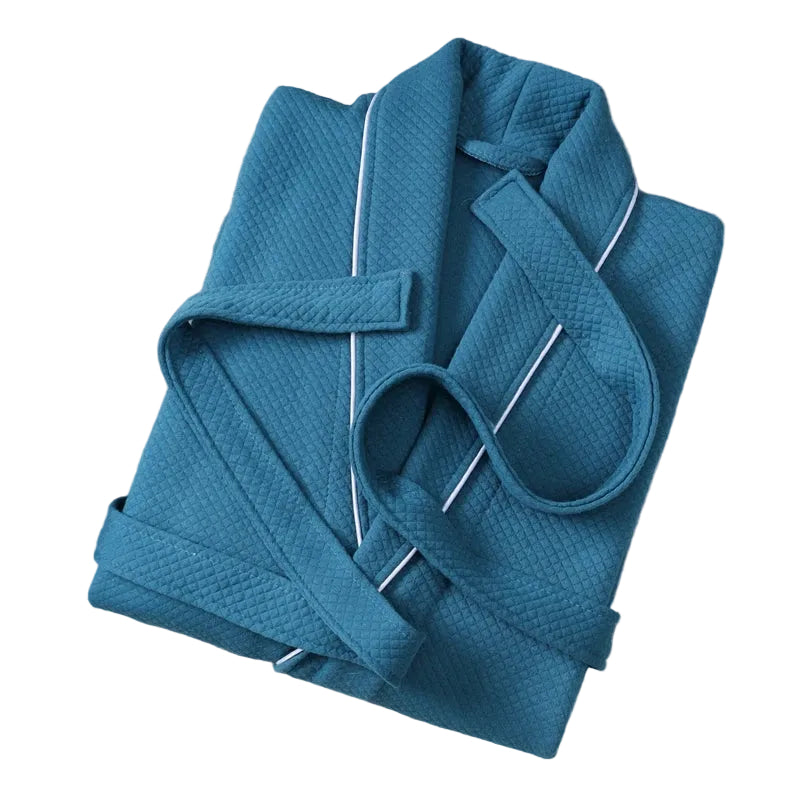 Peignoir Michel pour homme, modèle doux et agréable en tissu texturé bleu, présenté plié avec sa ceinture sur fond blanc.