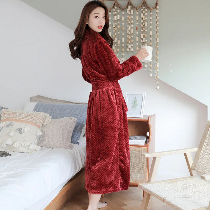 Peignoir femme Morwenna chaud et confortable, modèle long en polaire rouge, porté à la maison pour un maximum de douceur et de bien-être.