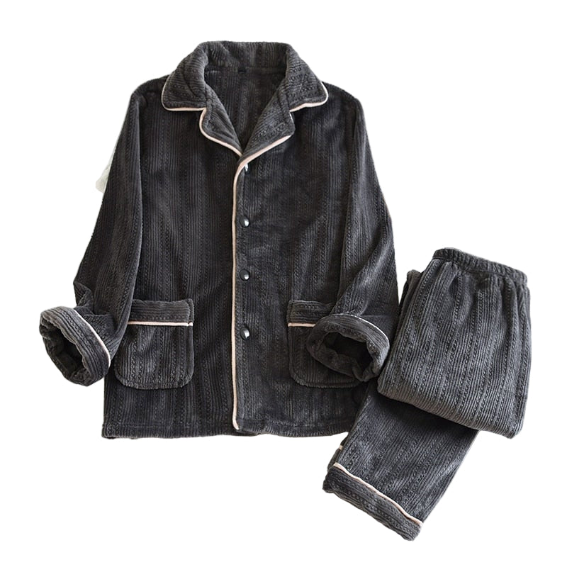 Pyjama homme Nadège en tissu doux côtelé gris anthracite, composé d’un haut à manches longues avec col à revers, boutons contrastés et deux poches plaquées, accompagné d’un pantalon assorti à taille élastique. Ensemble confortable et élégant, idéal pour des soirées cocooning.