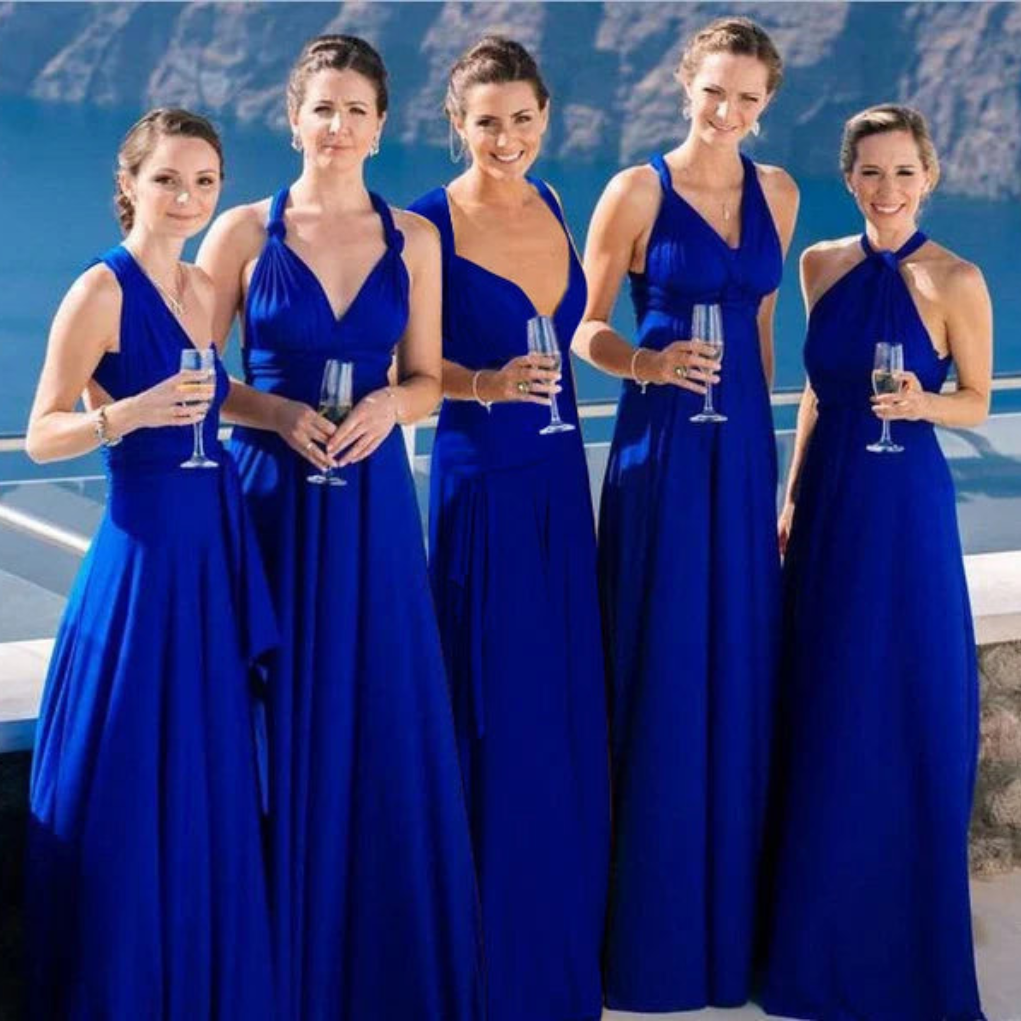 Un groupe de cinq femmes portant des robes longues bleu royal, idéales pour des occasions spéciales. Chaque robe présente un design élégant avec un décolleté plongeant ou un dos nu croisé, mettant en valeur la silhouette tout en offrant un confort optimal. Ces robes en polyester fluide sont parfaites pour un mariage, une soirée ou tout événement formel.