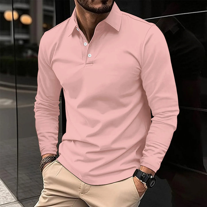 Polo à manches longues de couleur rose pastel avec col classique et boutons blancs. Un choix élégant et confortable, parfait pour un look décontracté ou semi-formel, adapté à diverses occasions.