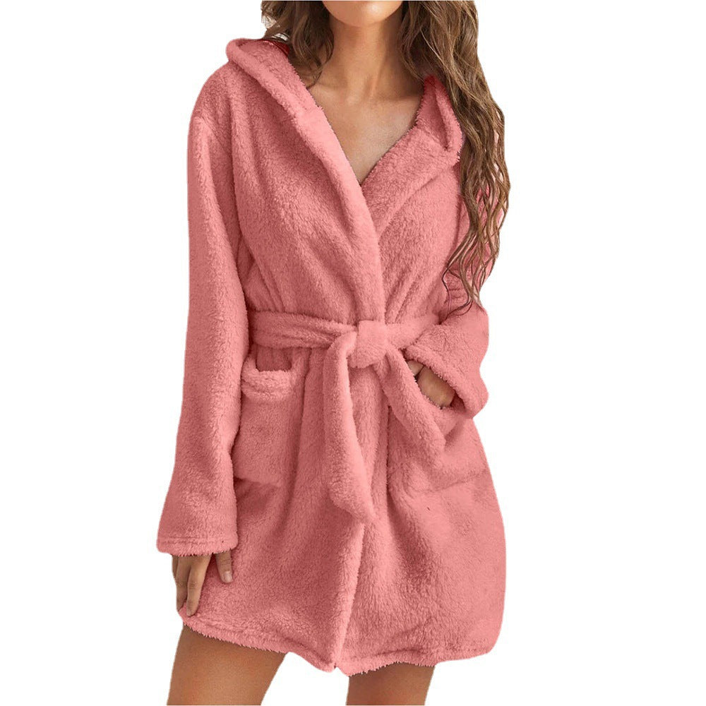 peignoir court rose en tissu pelucheux, avec capuche, ceinture à nouer et poches, porté par une femme sur fond blanc.