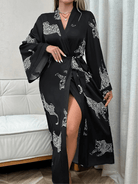 Femme portant le peignoir Noelia en satin noir à motifs léopard blanc, avec manches longues évasées et ceinture nouée à la taille. Style chic, fluide et confortable, parfait pour des moments de détente à la maison avec une touche sophistiquée.