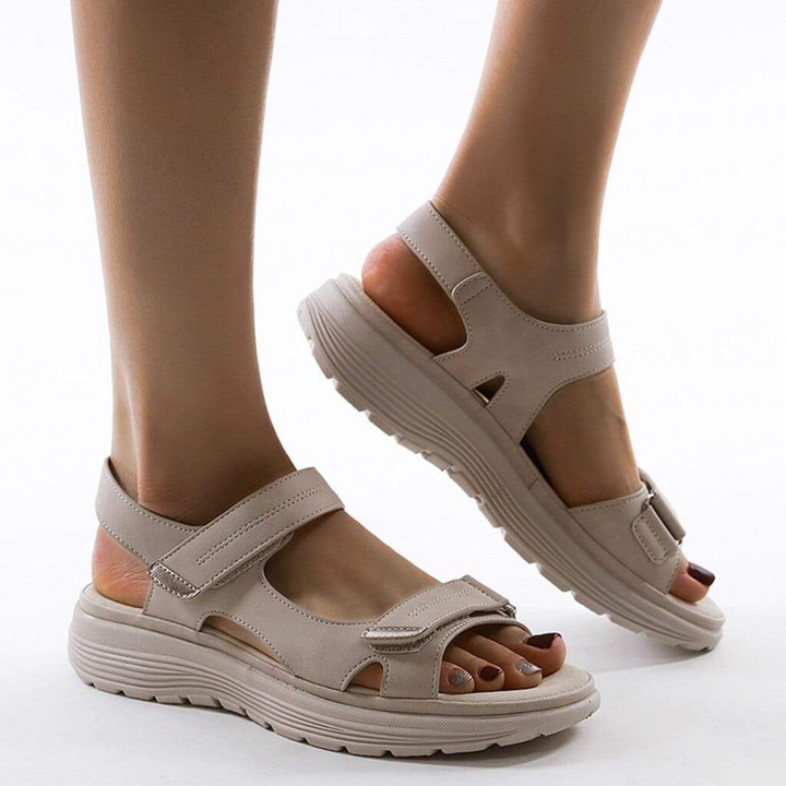 Sandales beige avec fermeture velcro, semelle épaisse et flexible, offrant un confort optimal pour les randonnées et les longues marches en plein air.