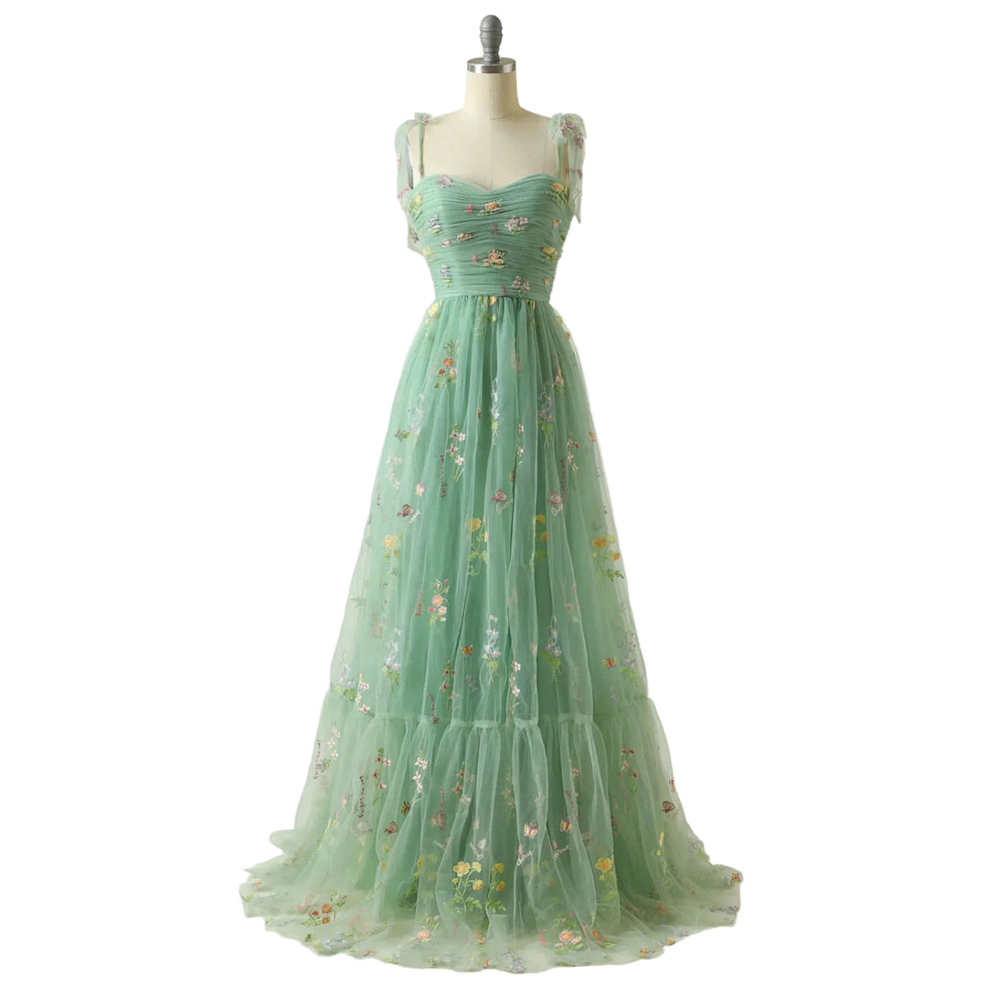 Vert menthe en tulle brodé de fleurs, bustier plissé, fines bretelles nouées et jupe fluide évasée, présentée sur mannequin.