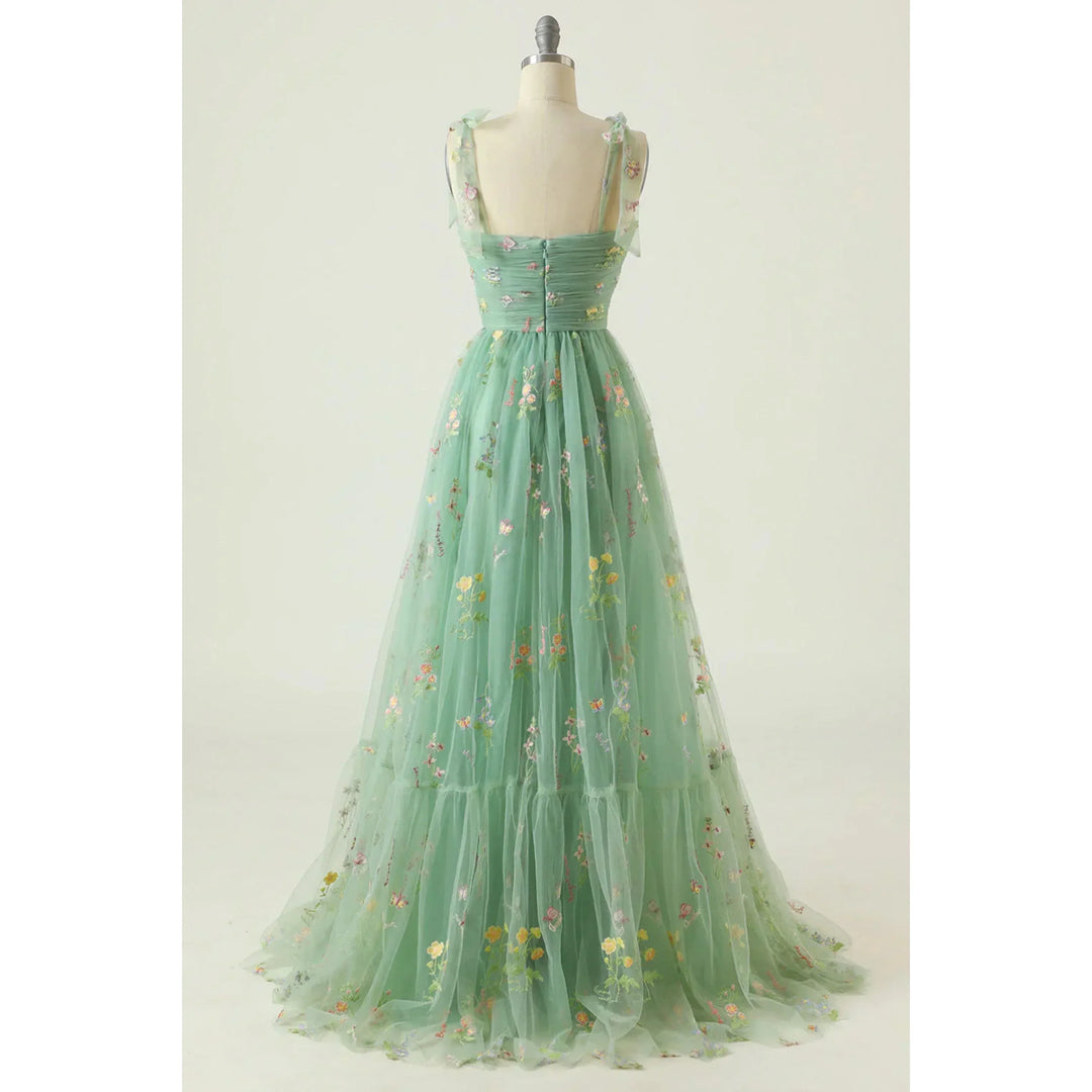 Vert menthe en tulle brodé de fleurs, bretelles nouées, taille marquée et jupe fluide évasée, présentée sur mannequin.