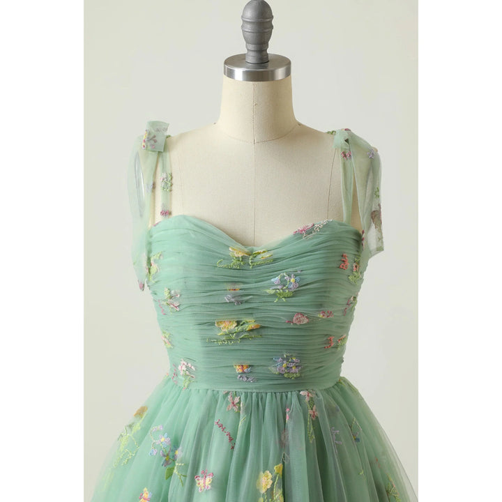 Vert menthe bustier plissé en tulle brodé de petites fleurs, fines bretelles en voile et taille cintrée.