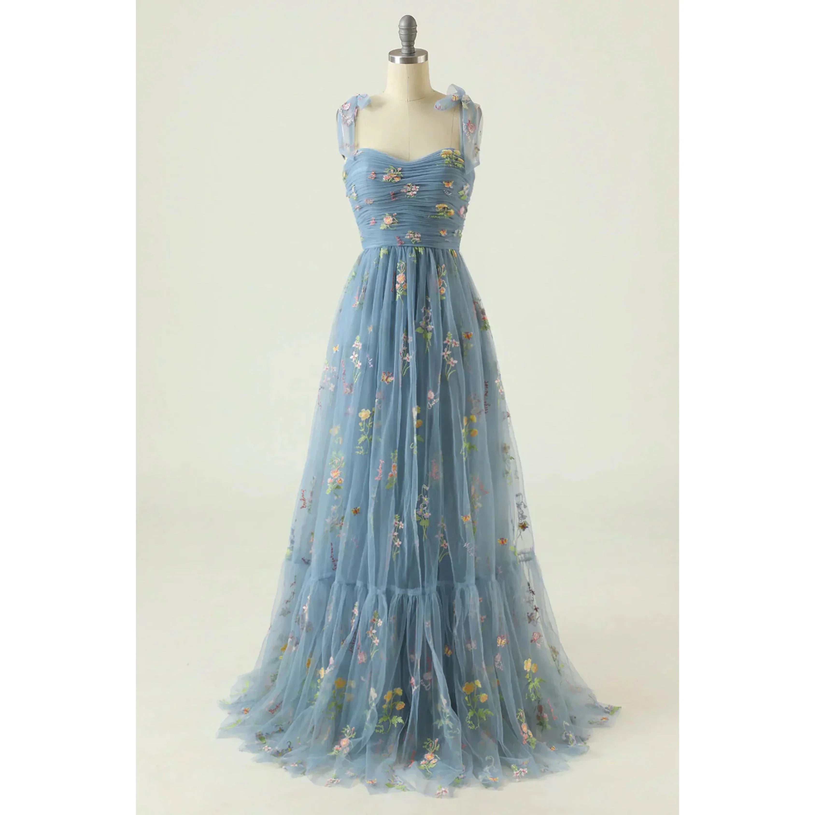 Bleu ciel en tulle brodé de fleurs, bustier plissé, fines bretelles en voile et jupe fluide évasée, présentée sur mannequin.