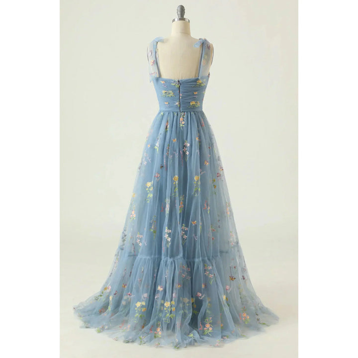 Bleu ciel en tulle brodé de fleurs, bretelles en voile, dos zippé, taille cintrée et jupe fluide évasée, sur mannequin.