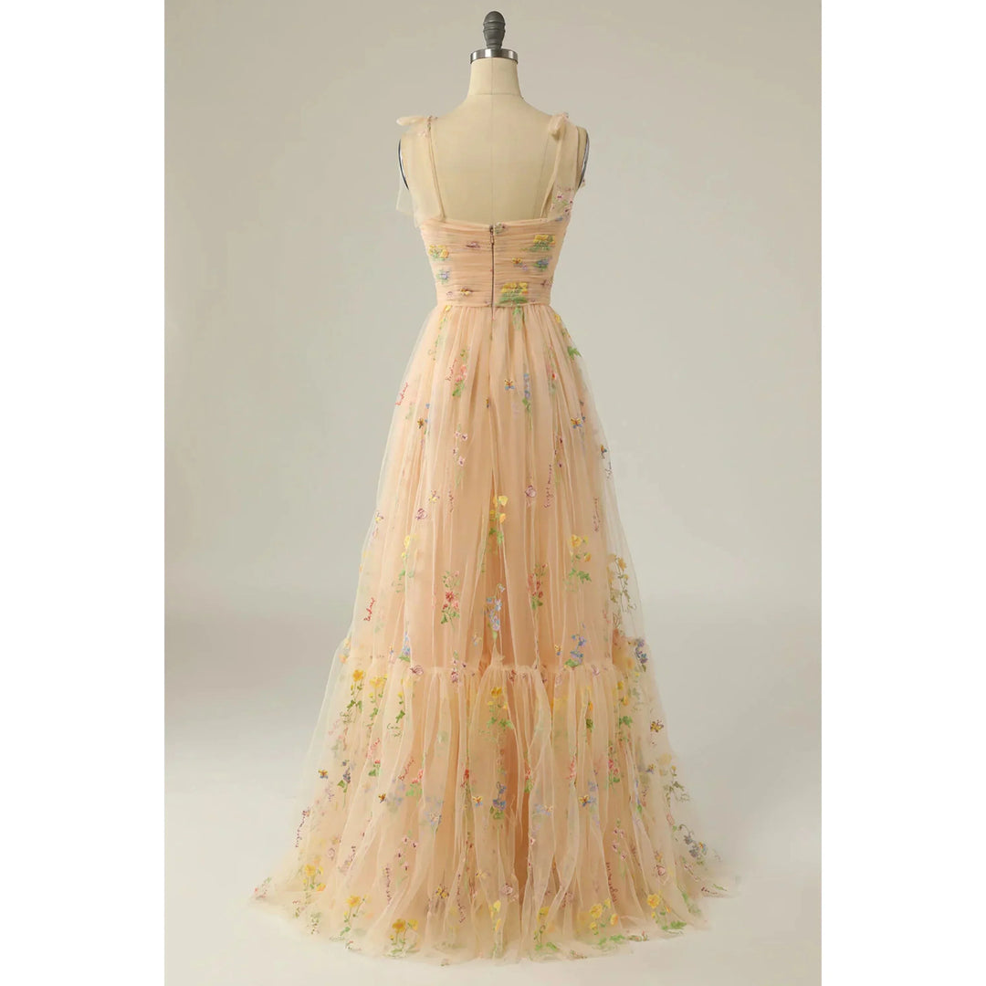 Beige nude en tulle brodé de fleurs, dos zippé, fines bretelles en voile et jupe fluide évasée, présentée sur mannequin.