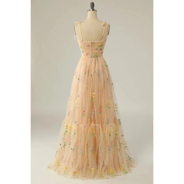 Beige nude en tulle brodé de fleurs, dos zippé, fines bretelles en voile et jupe fluide évasée, présentée sur mannequin.