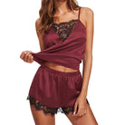 Femme portant le pyjama satin Odalys en couleur bordeaux, avec un top à bretelles fines et un short délicatement orné de dentelle noire, parfait pour un look élégant et confortable.