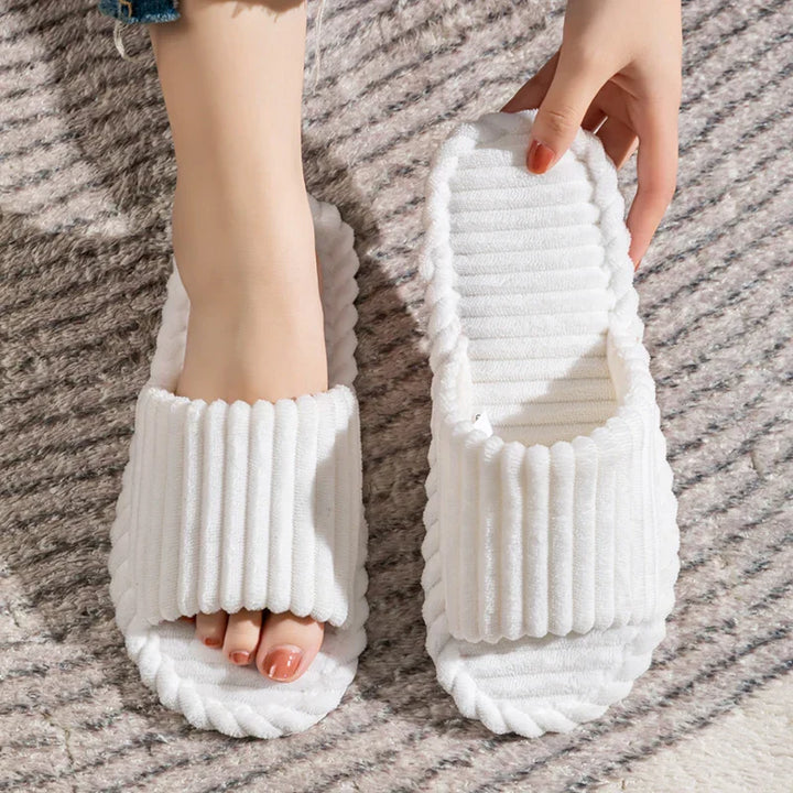 Chaussons élégants et modernes en couleur blanche, parfaits pour un look lumineux et décontracté. Leur bande douce et moelleuse assure un confort optimal, tandis que la semelle souple garantit une sensation agréable sous les pieds. Idéals pour la détente à la maison tout en restant à la mode.