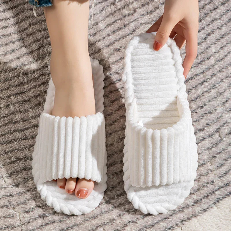 Chaussons élégants et modernes en couleur blanche, parfaits pour un look lumineux et décontracté. Leur bande douce et moelleuse assure un confort optimal, tandis que la semelle souple garantit une sensation agréable sous les pieds. Idéals pour la détente à la maison tout en restant à la mode.