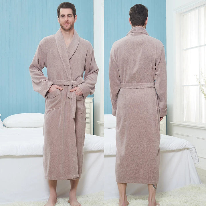 Homme portant le peignoir Pascal, un modèle épais et chaleureux en tissu éponge beige, présenté en vue de face et de dos dans une chambre lumineuse.